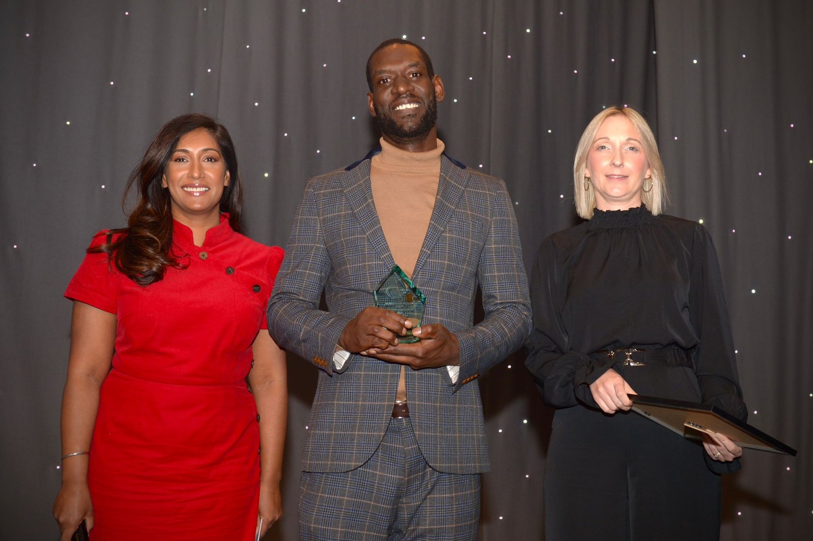 Kam smiling with his award