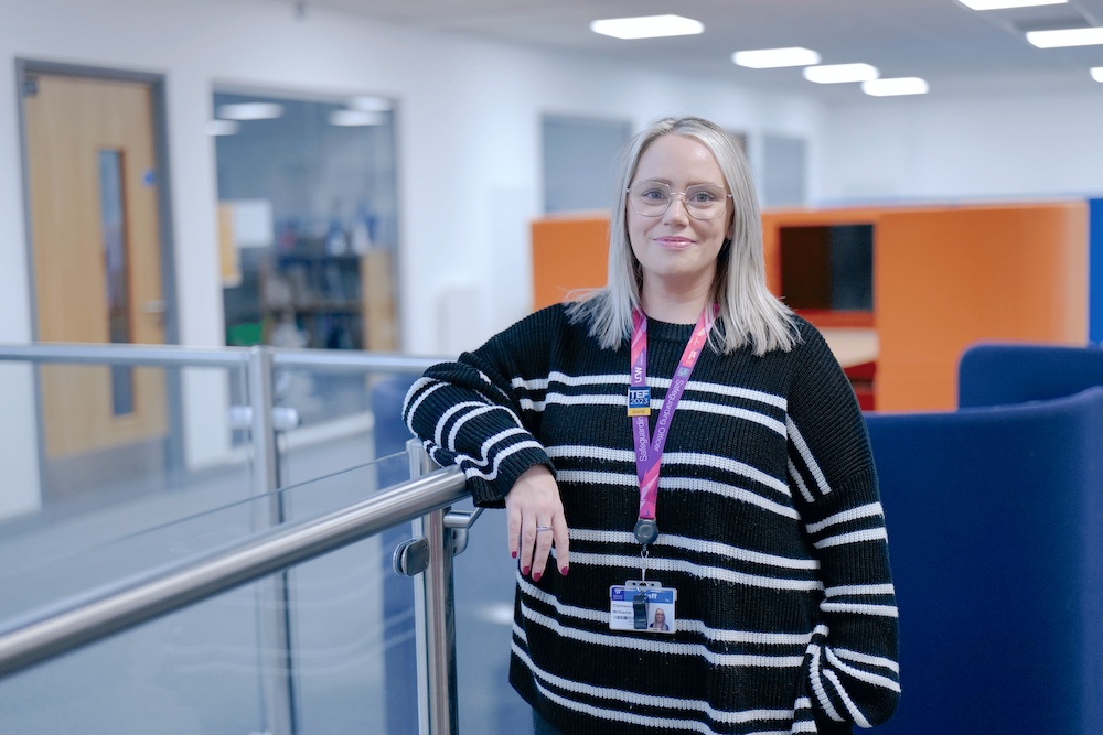 Clem standing with her elbow on a rail