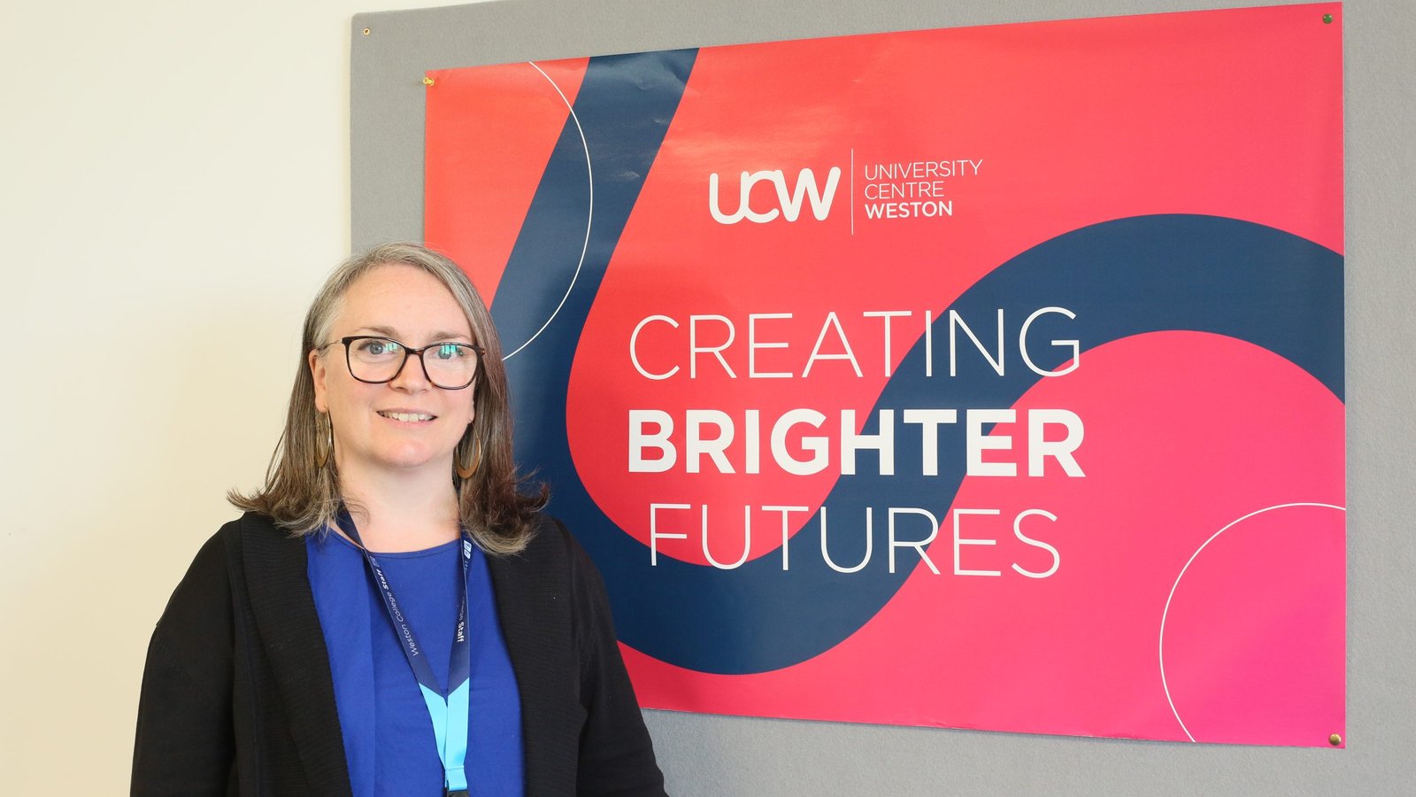 Zoe miller standing infront of a creating brighter futures sign